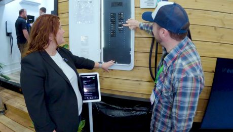Photo of a man and a woman looking a electrical panel